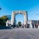 People walking beneath the Bridge of Remembrance, a stone arch monument in Christchurch, New Zealand